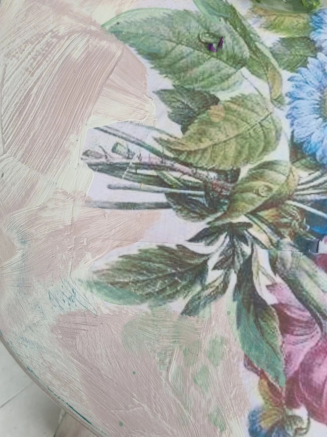 A painted dressing table in white and pale pink with large florals in blues and mauves and text in turquoise that reads 'turn your face to the sun'. The whole piece is distressed in the shabby chic style.