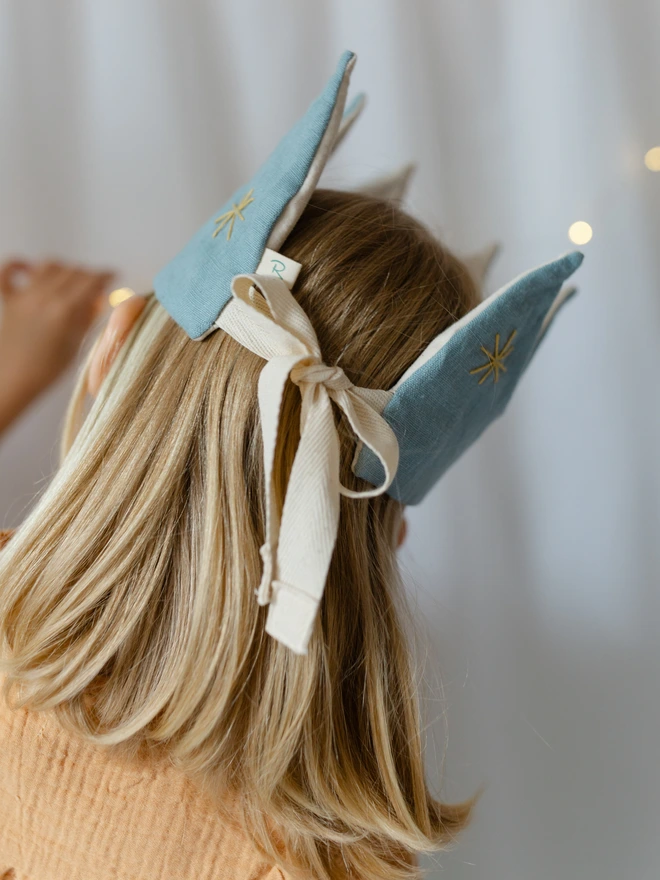 Girl wearing her blue birthday crown showing ties