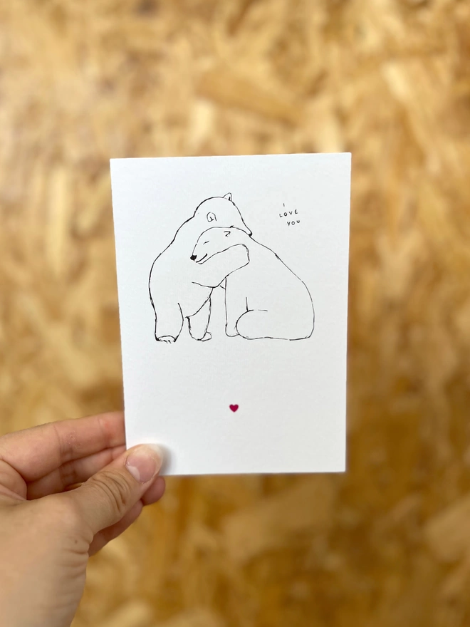 a greetings card featuring two polar bears hugging each other with the phrase “I love you” and a small pink heart