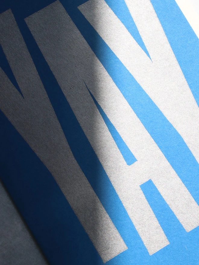 Blue greeting card with the word yay printed in silver using a linocut block