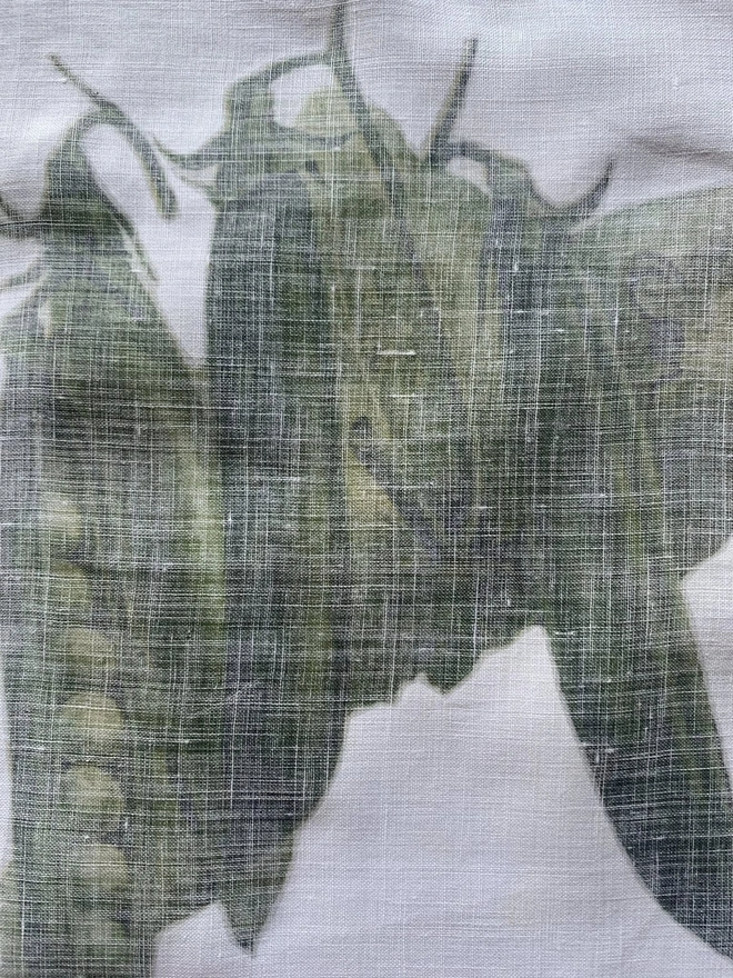 A close up of the reverse of some vintage cotton linen printed with pea pods