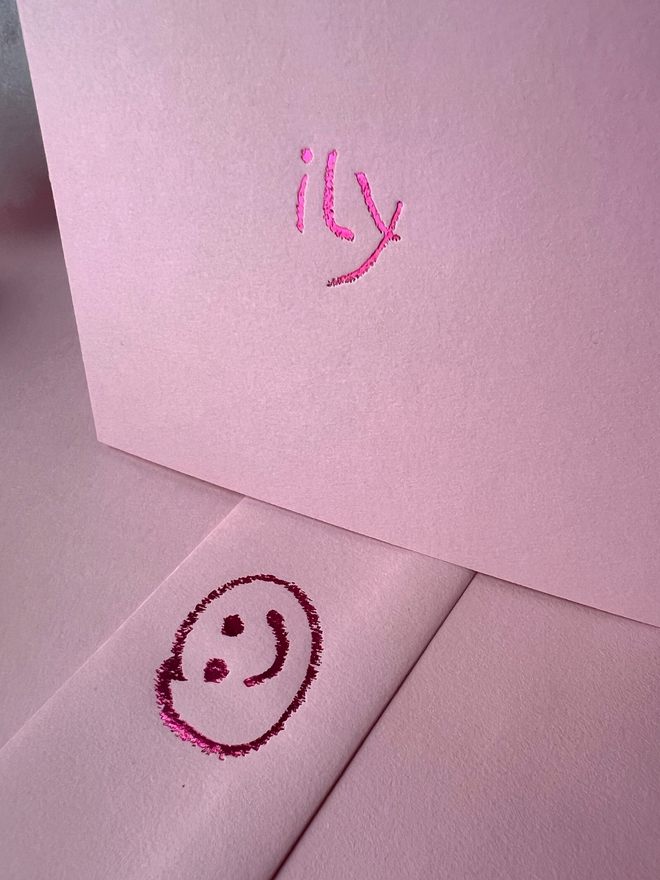 pastel pink coloured card with ily  short for 'I love you' hand foiled in kids hand writing