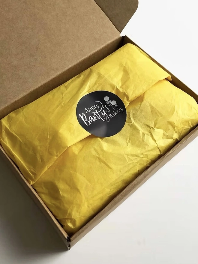 Black And Gold 'Happy Birthday' Cake Pops, the packaging of the cake pops with it's yellow wrapping paper. 