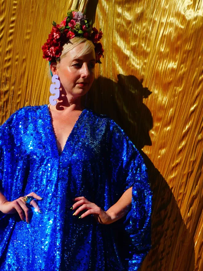 Fumbalina Royal Blue Holographic Sequin V-neck Kaftan Gown seen with her hands on her hips.