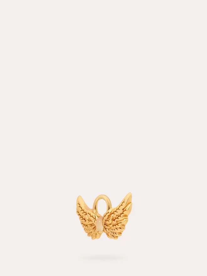 side view of a gold Hermes Wings Charm featuring an opal stone