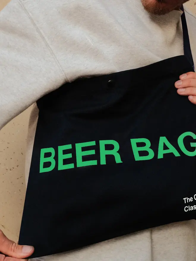 'Beer Bag' Musette Bag, against a grey background. 