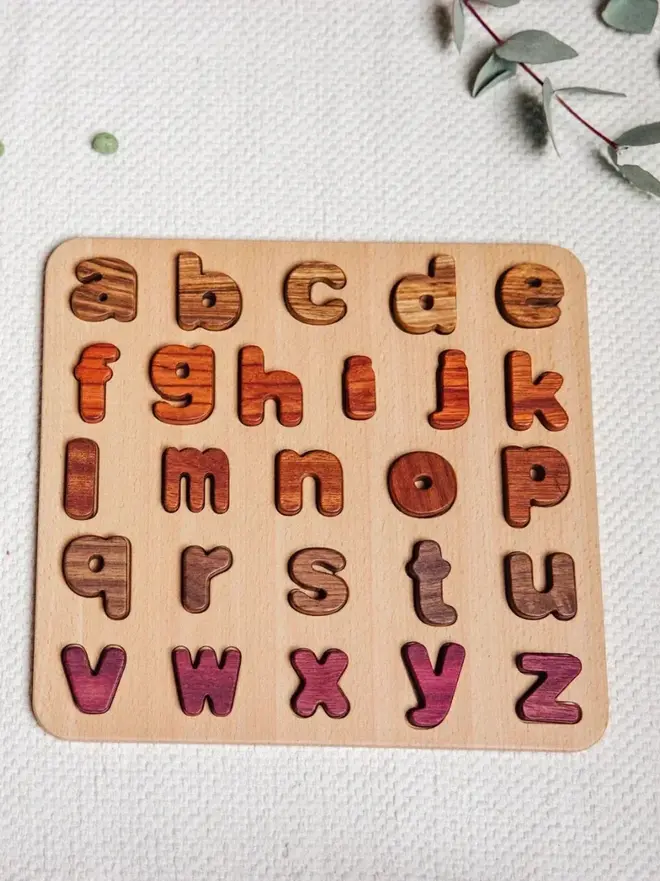 Wood Alphabet Puzzle Heirloom Toy, on a white table. 
