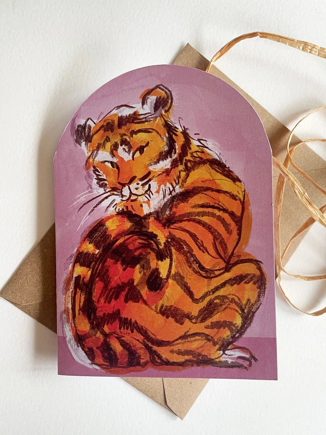 Esther kent illustrated arch-shaped greetings card, showing brown and orange tiger on a pink background