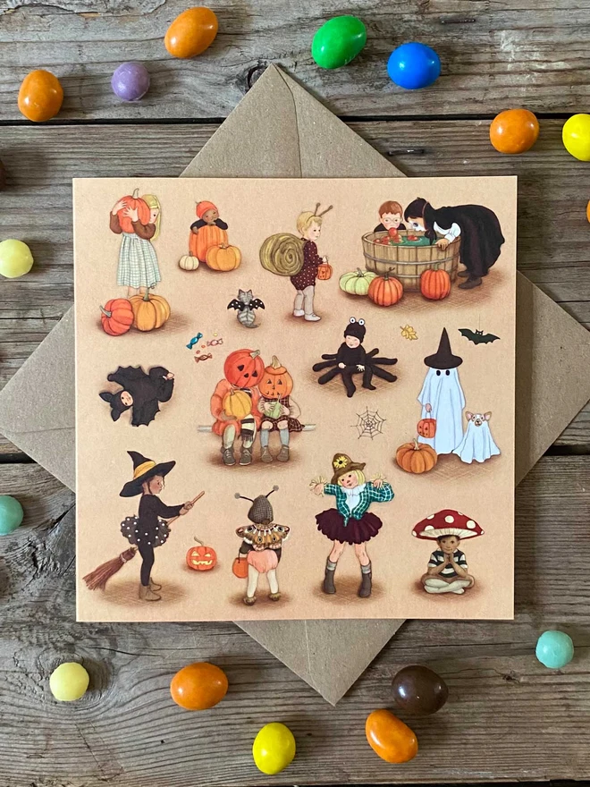 halloween card featuring children doing halloween activities surrounded by sweets