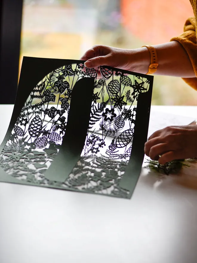 Rosie holding letter D winter theme dark green botanical papercut