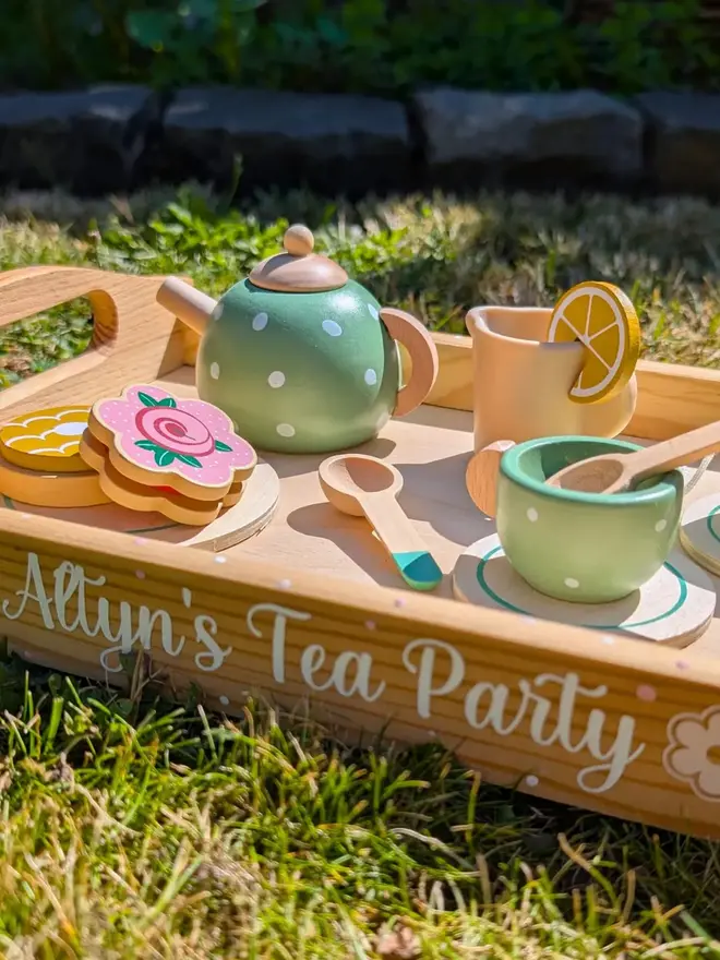personalised wooden tea set. a personalised wooden tray and toy tea set on grass.