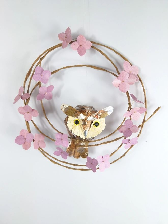 long eared owl sculpture, perched on a wreath of pink hydrangea blooms