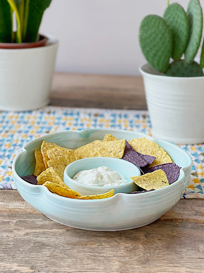 flower shaped chip and dip bowl on table with tortilla chips and dip