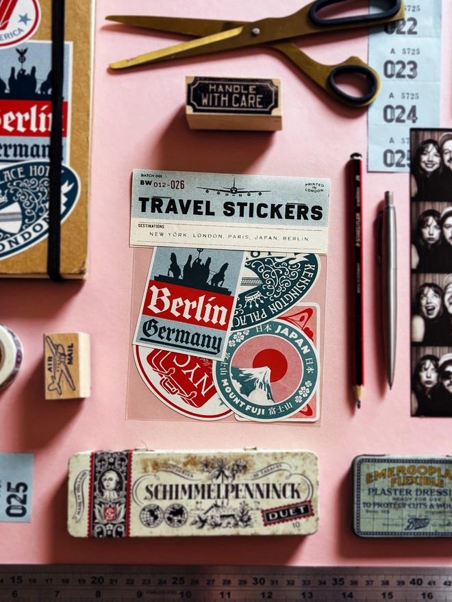 Vintage Travel Stickers for New York, Japan, Paris, London and Berlin in a cellophane bag, surrounded by stationary 