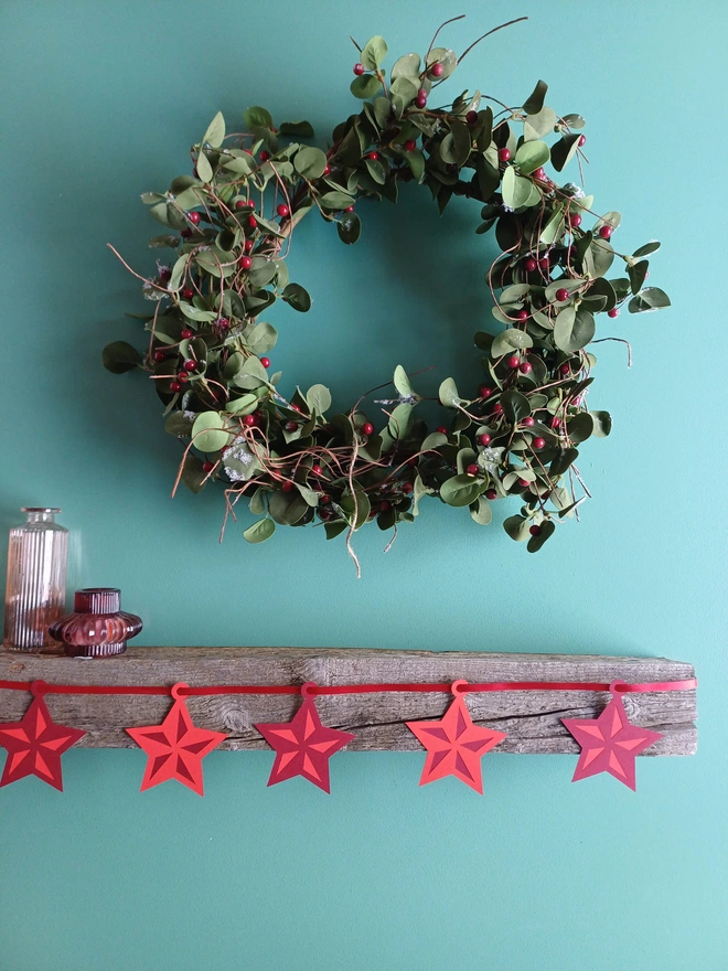 Red Star Garland Displayed on Mantelpiece with Christmas Wreath