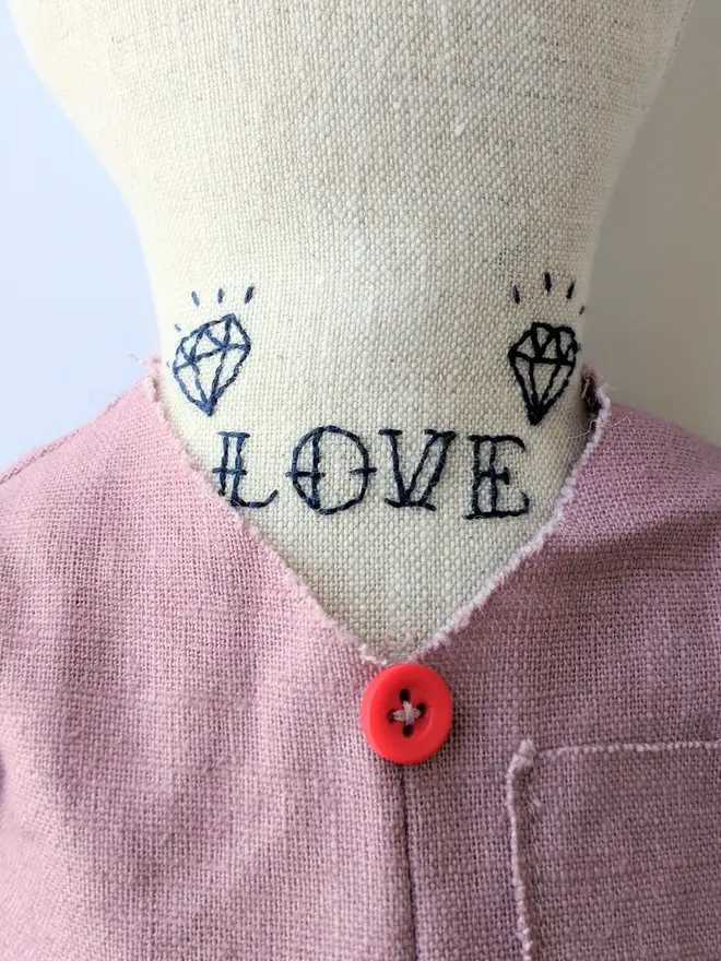 tattooed bear doll. a cream linen bear doll with embroidered neck tattoos and a pink waistcoat.