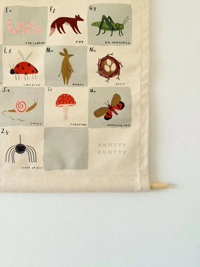 Woodland Alphabet Fabric Banner, hanging on a white wall. 