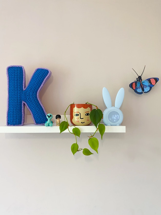 Crocheted Letter K in Blue and Lilac, on child's shelf