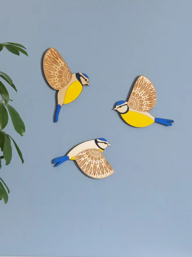 Folk Art Wooden Blue Tits (Set Of 3), wooden blue tits hung up on a wall, flying. 