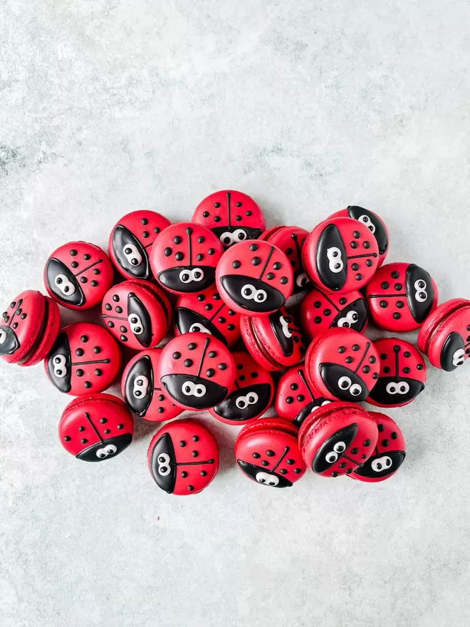 a pile of red ladybug macarons