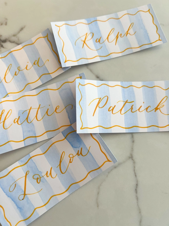 Personalised calligraphy event place cards, blue striped coloured place cards with orange calligraphy name