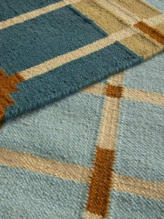 Corbie Flatweave Rug, a colourful rug sitting on a household floor. 