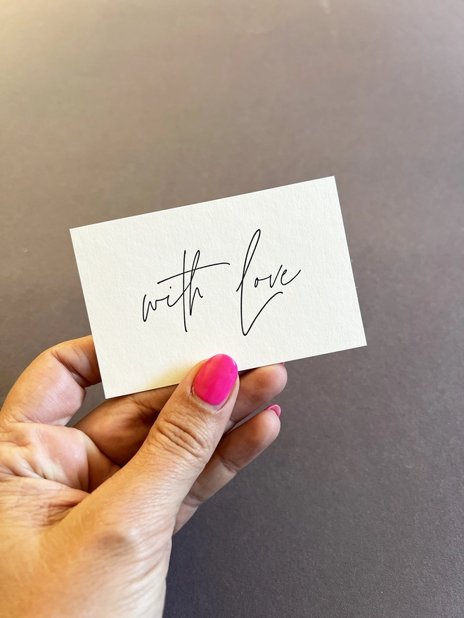 A hand holding the tiny note for comparison.