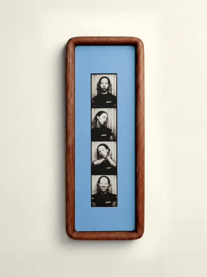 Baby blue  Mounted Photobooth Solid Wood Frame, hanging on a white wall. 