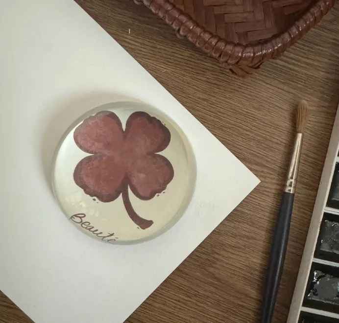 Burgundy clover
paperweights on a wooden background. 