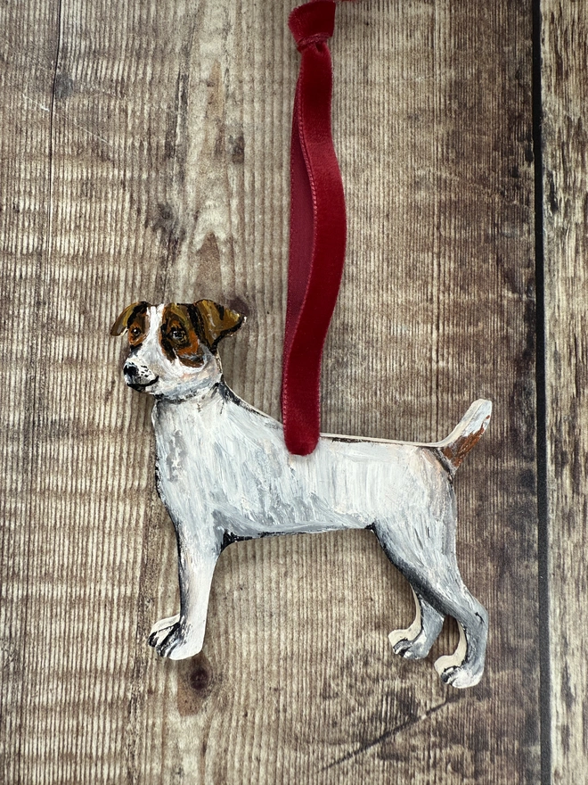 Smooth Haired Jack russell wooden Dog  Christmas Decoration With Red ribbon placed on a wooden background
