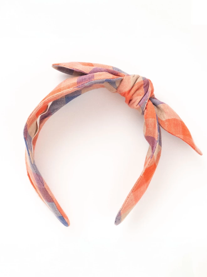 Side bow headband in reds and oranges