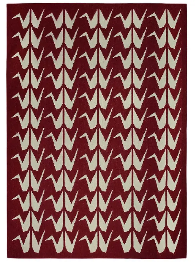 Crane Flatweave Rug, a colourful rug sitting on a plain surface. 