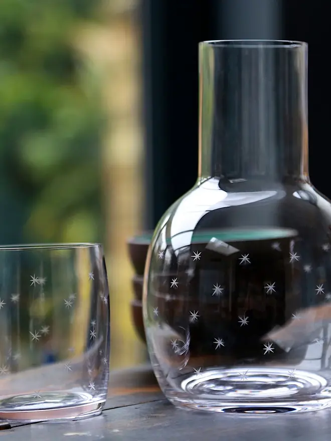 engraved stars crystal carafe set. a glass carafe and small glass patterned with small stars.