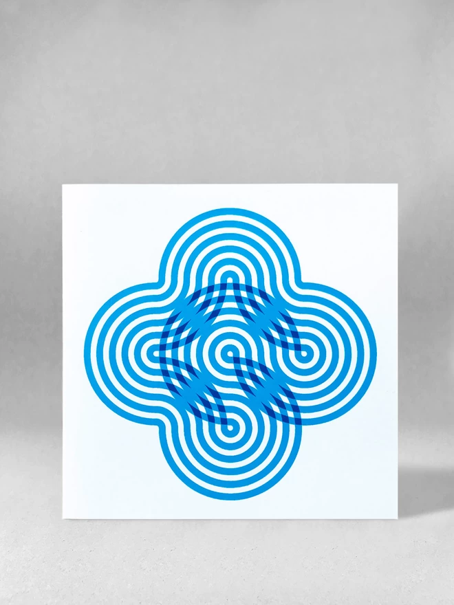  Six blue swirling stripes create a neat flower-like visual on the front of this card. This studio shot shows the card front on, stood on a light grey background.