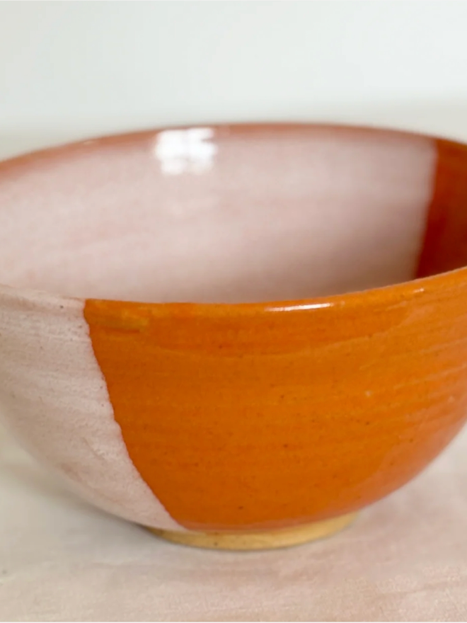 Cereal Bowl. A close up of an empty Orange Cereal Bowl. The lighter orange of the interior is visible.