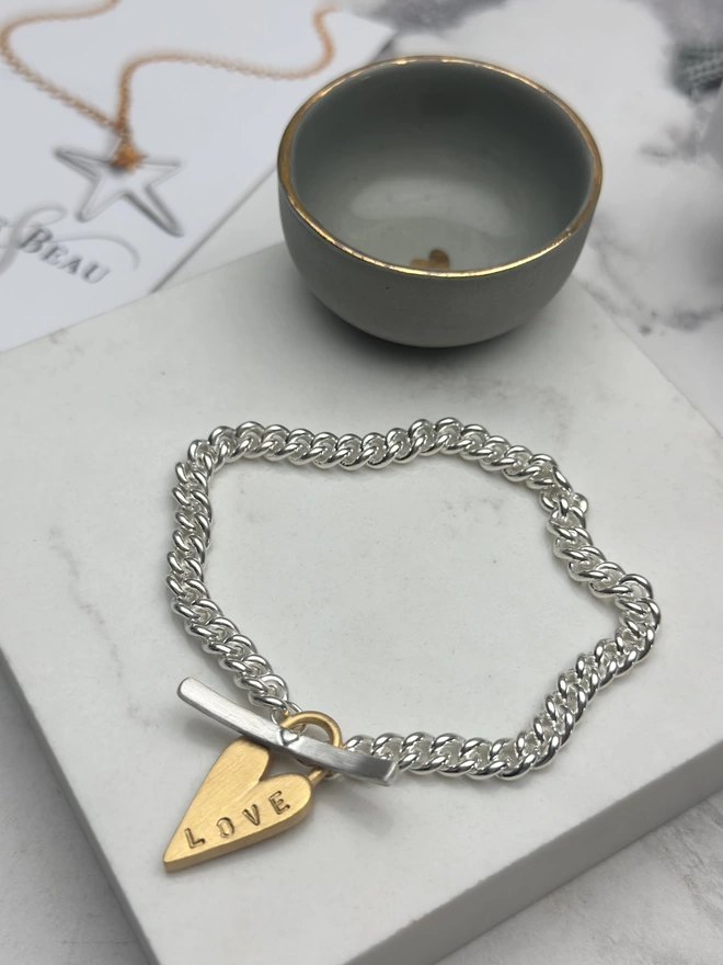 sterling silver chunky curb bracelet with silver t bar fastener and personalised gold chunky heart padlock charm. with gift box and pouch
