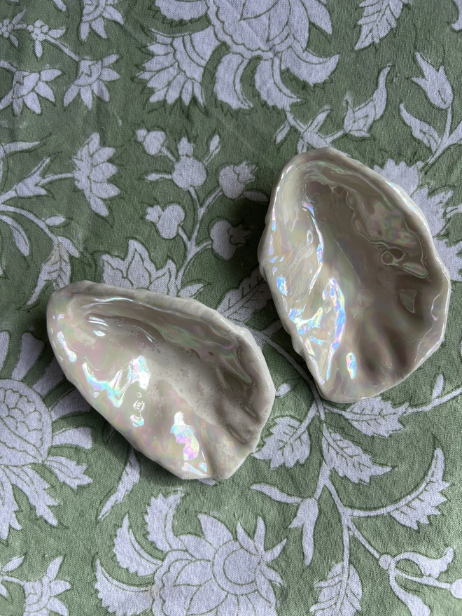 a pair of porcelain oyster shells handmade from a real oyster shell on a hand block printed table cloth from Jaipur