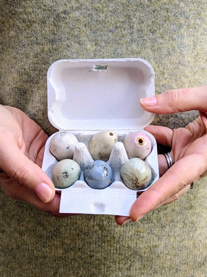 Hands holding ceramic eggs