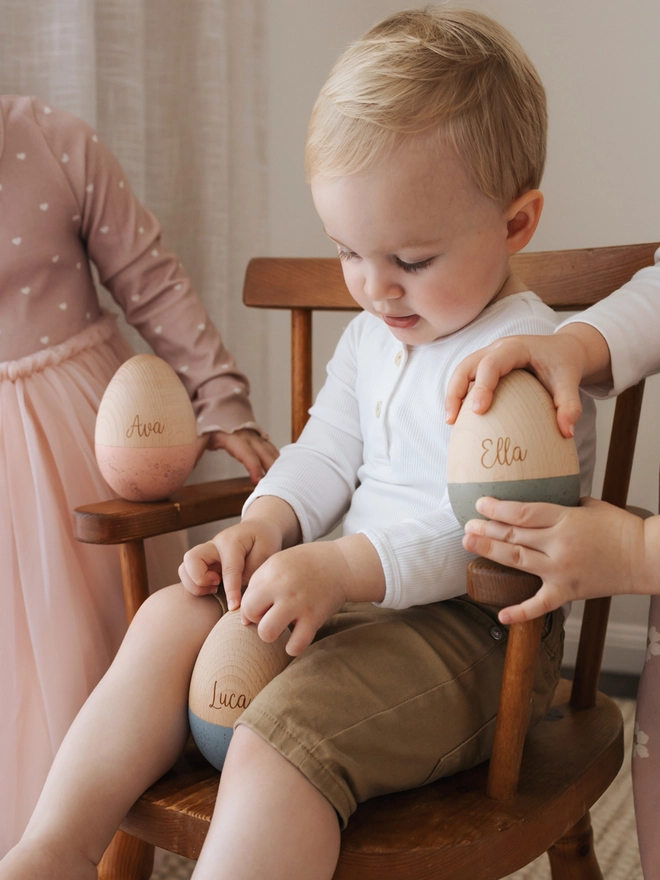 Children playing with wooden fillable toy eggs