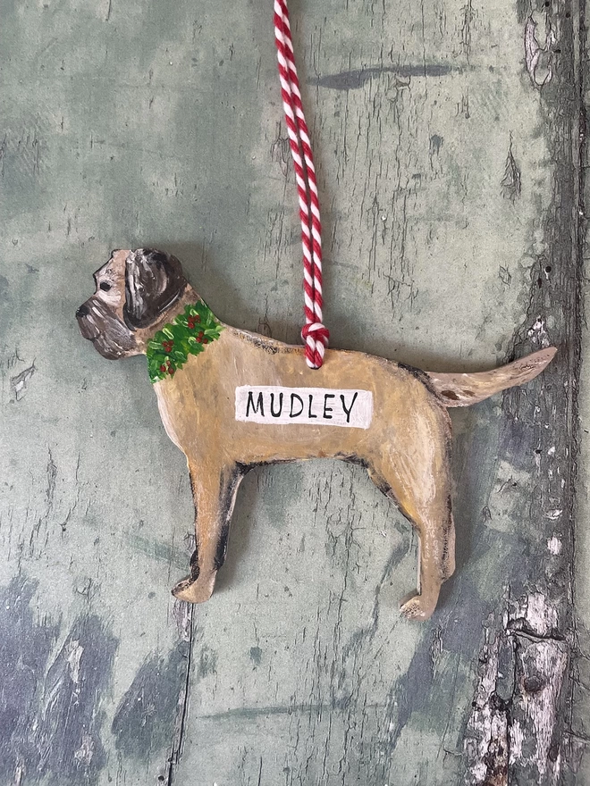 A border terrier Christmas decoration with handpainted Holly wreath round its neck and the name Mudley added