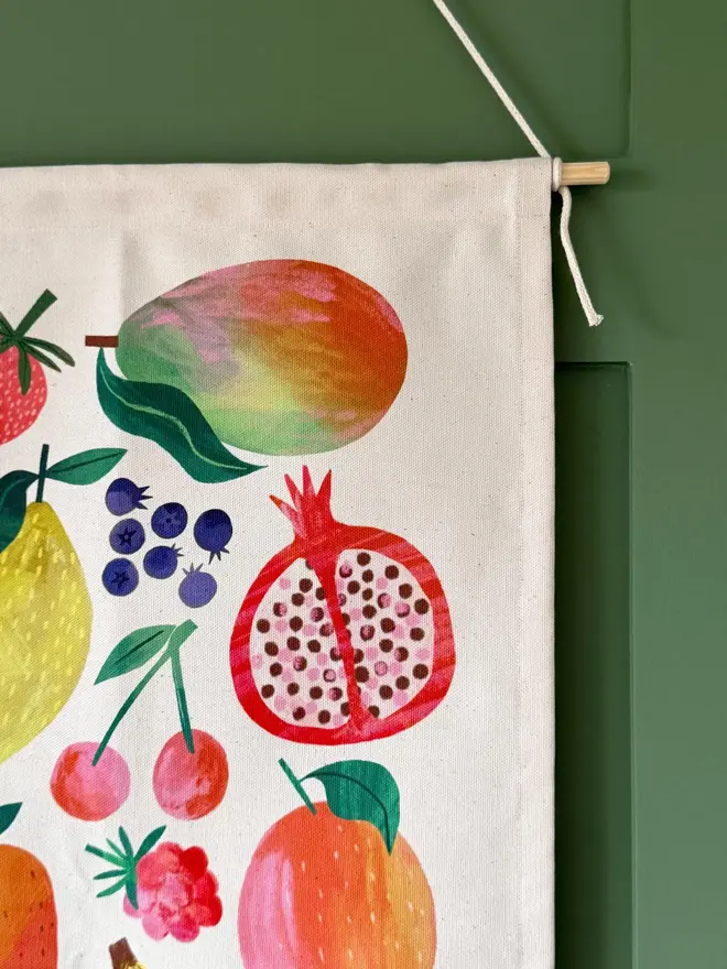 Fruit Print Fabric Banner, hanging on a green wall. 