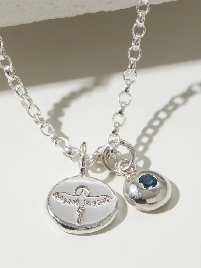 Close up of a Sterling silver Phoenix Pebble Necklace with a letter charm