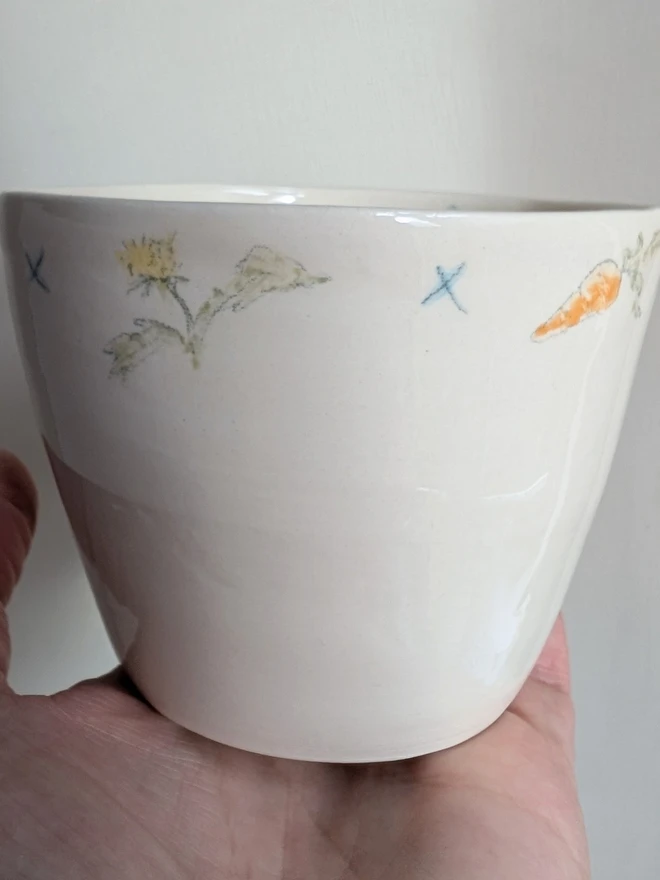 Hand painted white pottery cup with carrots dandelions and blue kisses