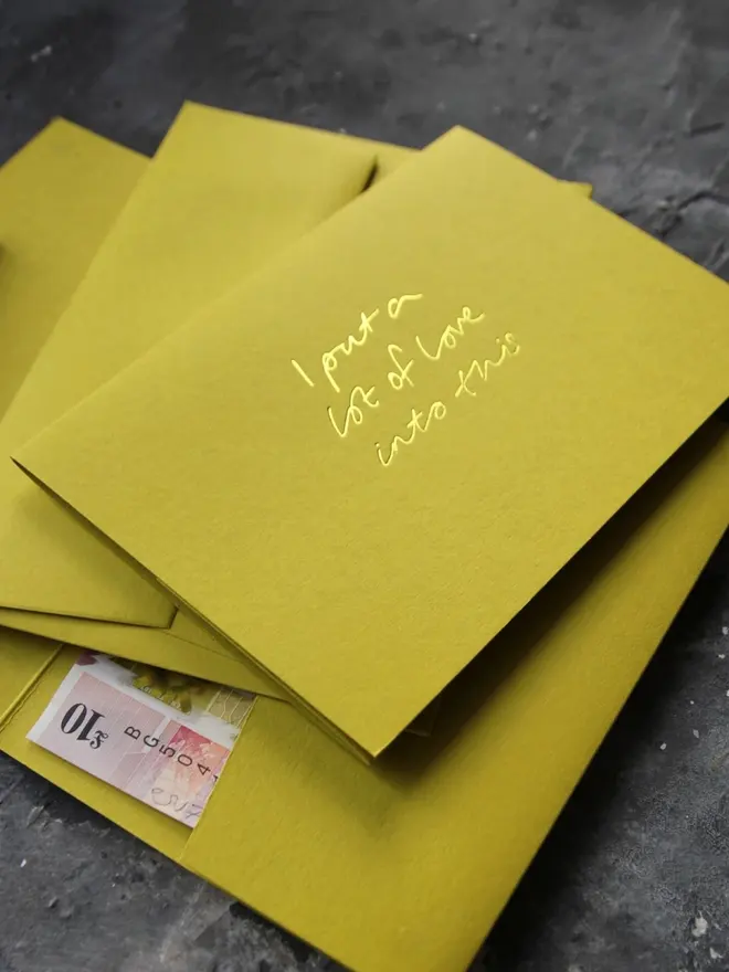 Hand foiled cash card or money wallet in a chartreuse green colour handfoiled in shiny yellow foil text which says ‘I put a lot of love into this’.