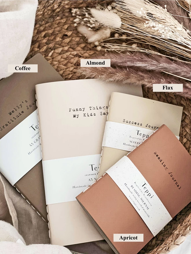 selection of journals in light pastel colours laid on top of each other