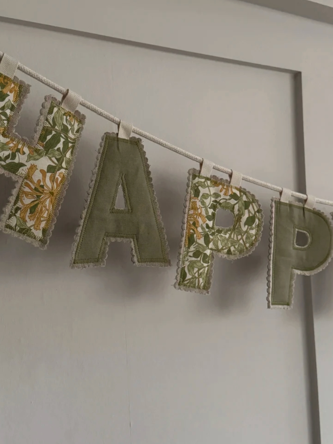 Birthday Garland Lettering. A banner reading ‘happy’.