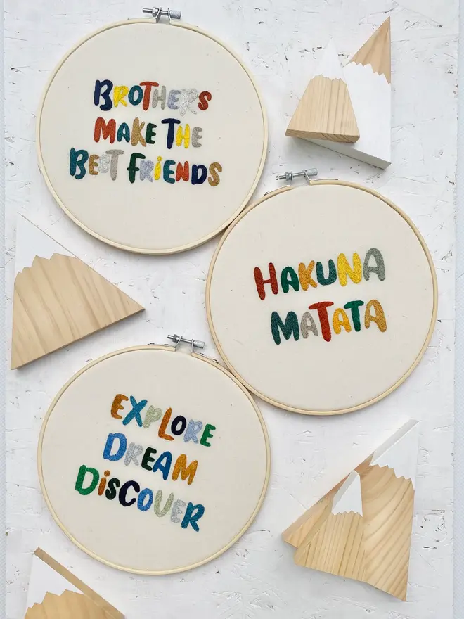 custom phrase embroidered hoop. three cotton hoops embroidered with positive phrases in colourful lettering.