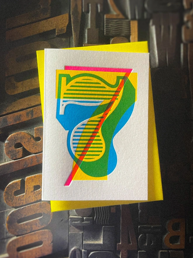 Handmade letterpress 7th birthday card featuring bold overlapping numerals printed in vibrant fluorescent cyan, magenta and yellow inks. Each card is individually hand printed using traditional letterpress techniques on luxury paper stock, creating a beautifully tactile finish with a deep impression and rich layered colours inspired by the CMYK printing process. Printed on a traditional letterpress from 1915. A wonderful artisan printed birthday card.