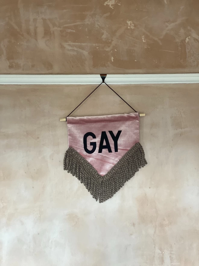 gay wording on handmade wall hanging