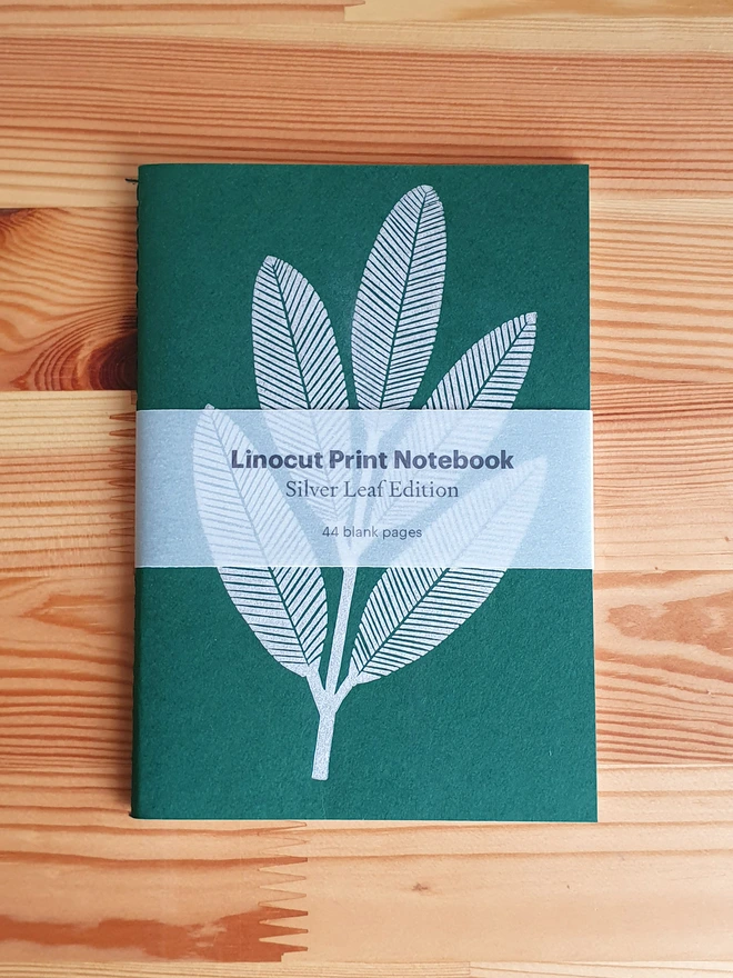 Green notebook with linocut sliver leaf on the cover